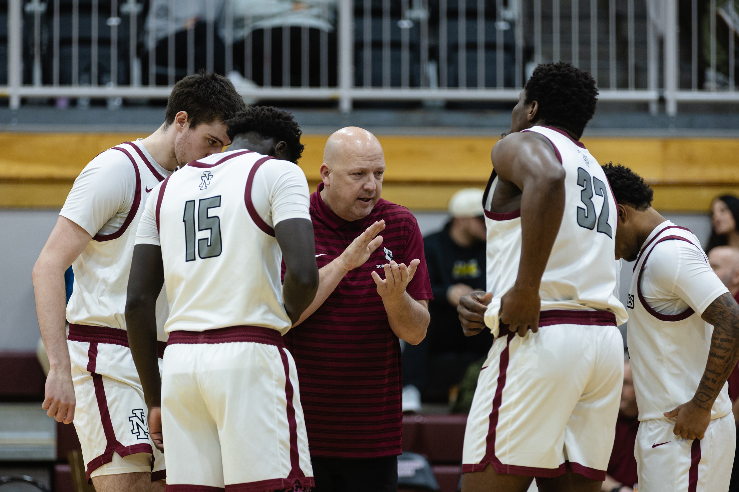 Head Coach Corey Symons gathers his team during a timeout in Christianson Gymnasium.