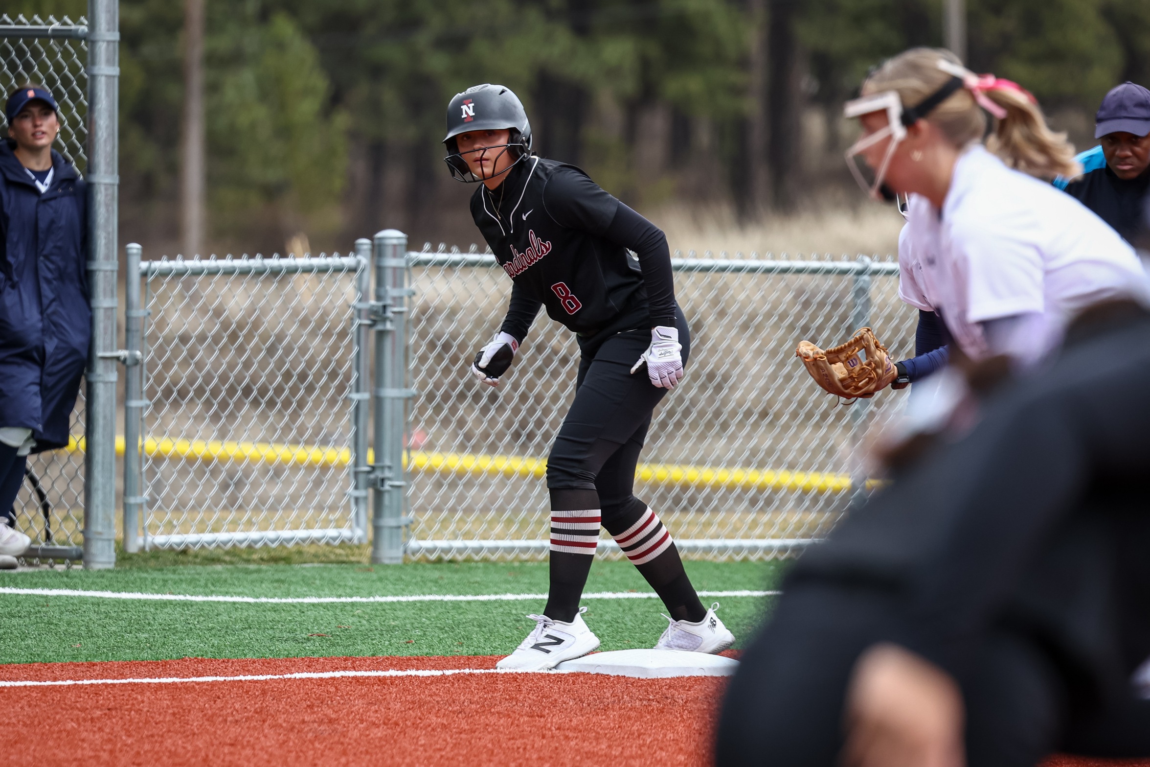 Aspen Roberts looks on from third base, ready to take action after the pitch.