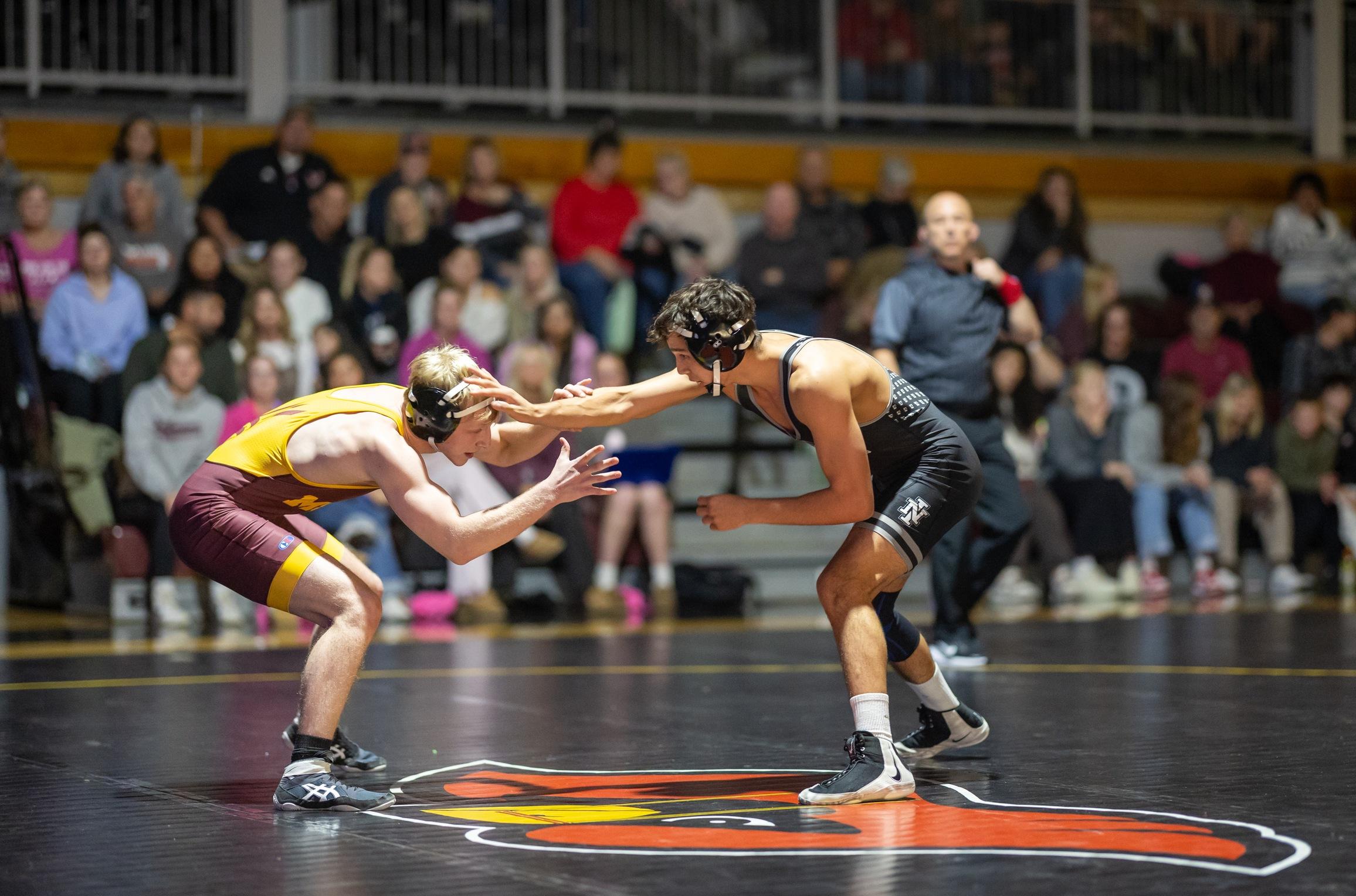 Colton Tucker with his hand on the head of Montana State University Northern opponent in Christianson Gymnasium.