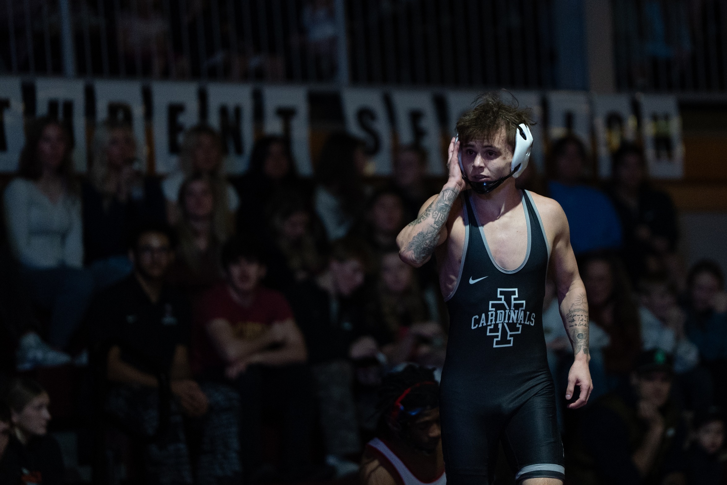 Owen Pritchard stands in Christianson Gymnasium during match against Clackamas with fans in the background.