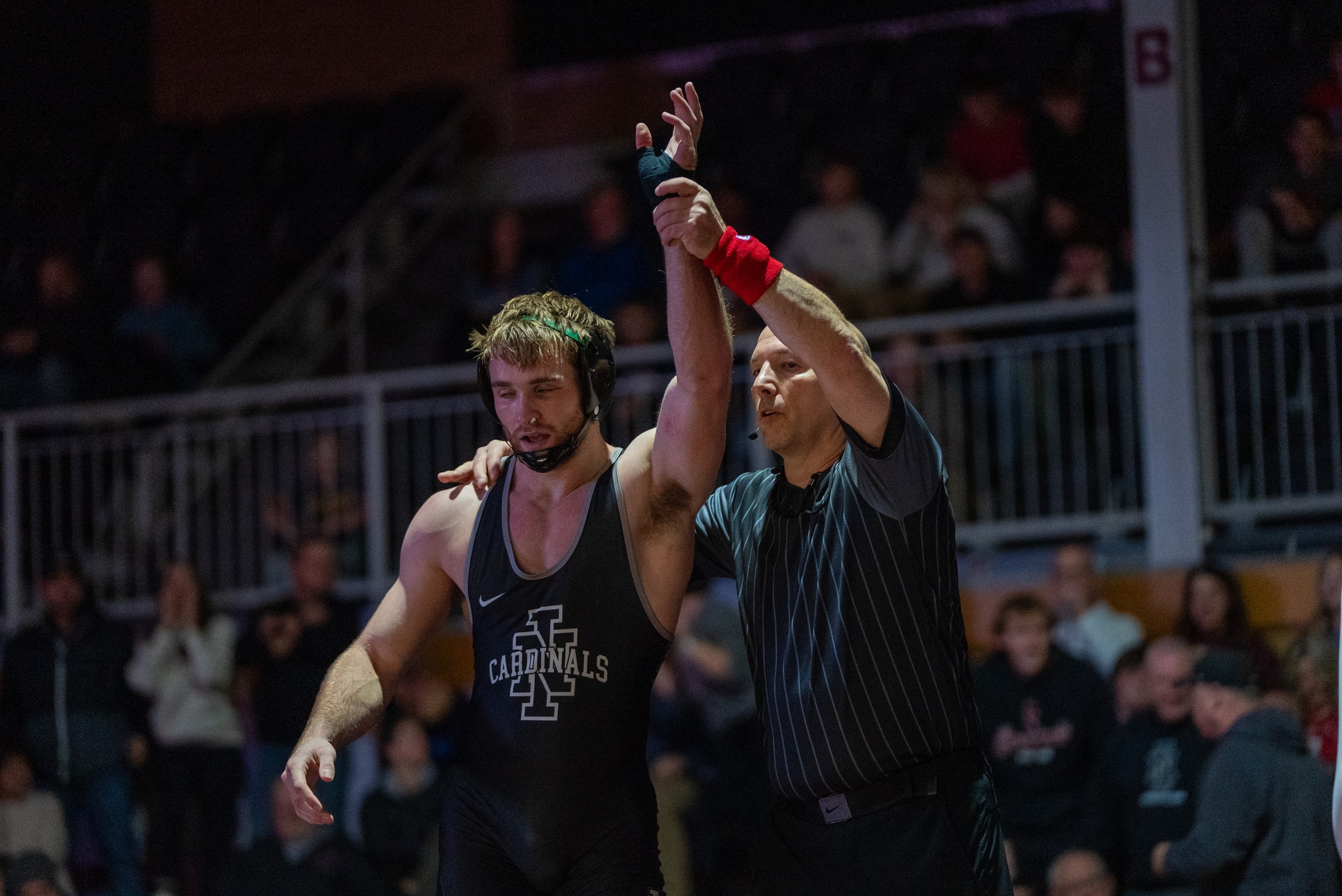 Colton Theobald being declared winner by official after a match in Christianson Gymnasium.